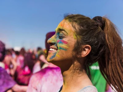 Photo portrait of a young woman with holi color on her face